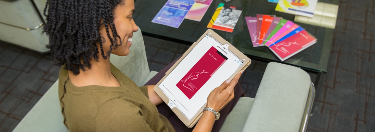 Read "Mobilizing Access to Scarce Health Information". A woman using a tablet.